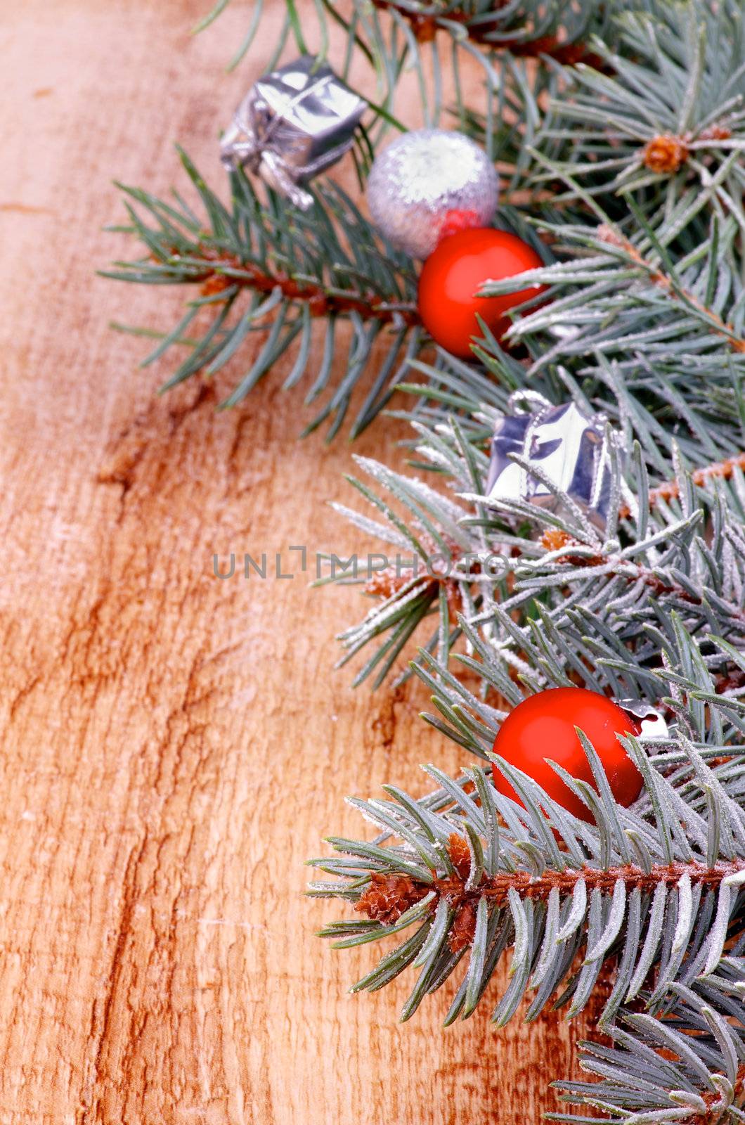 Christmas Decoration. Arrangement of Spruce Branch with Hoarfrost, Red and Silver Baubles closeup on Wooden background