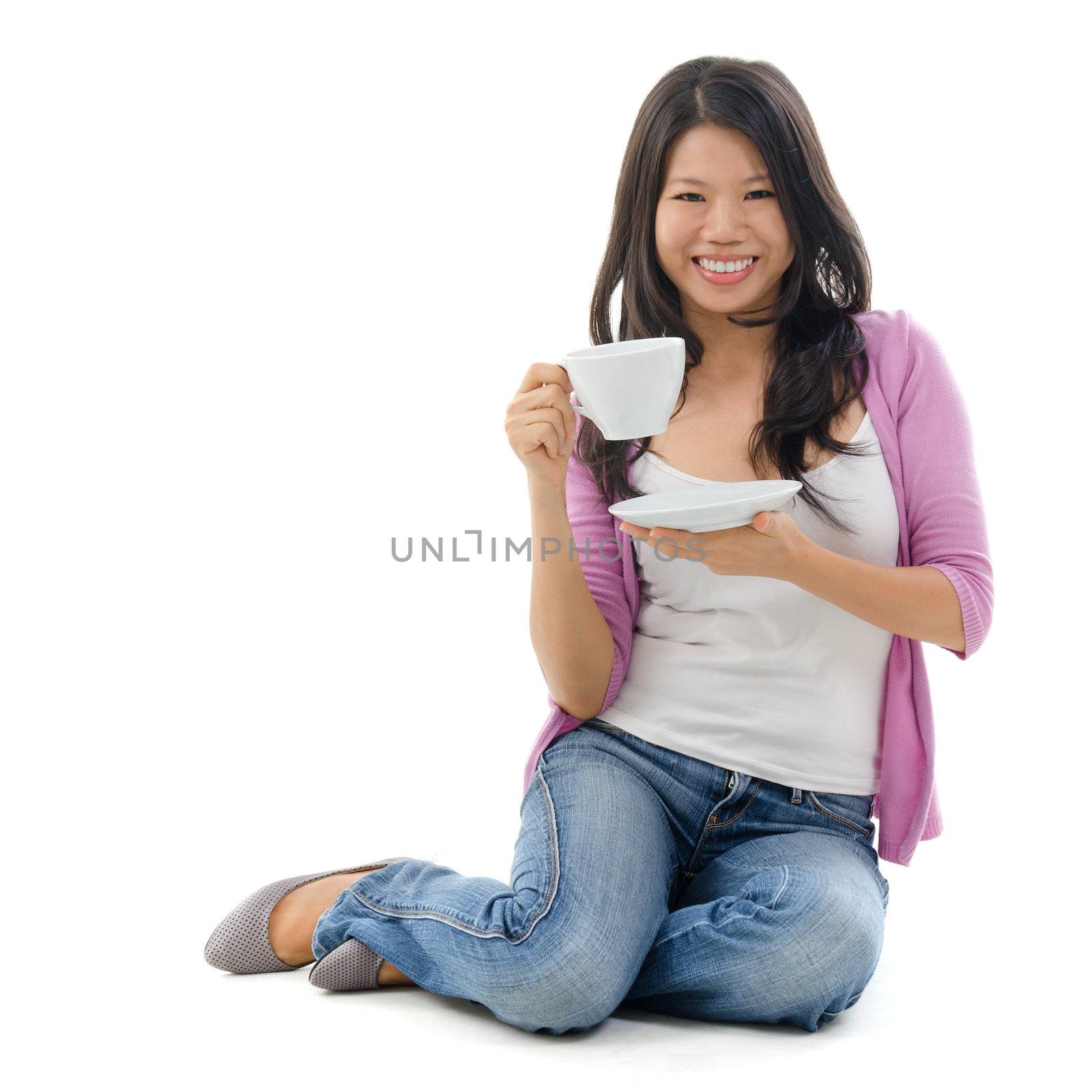 Asian female holding a cup of tea sitting over white background