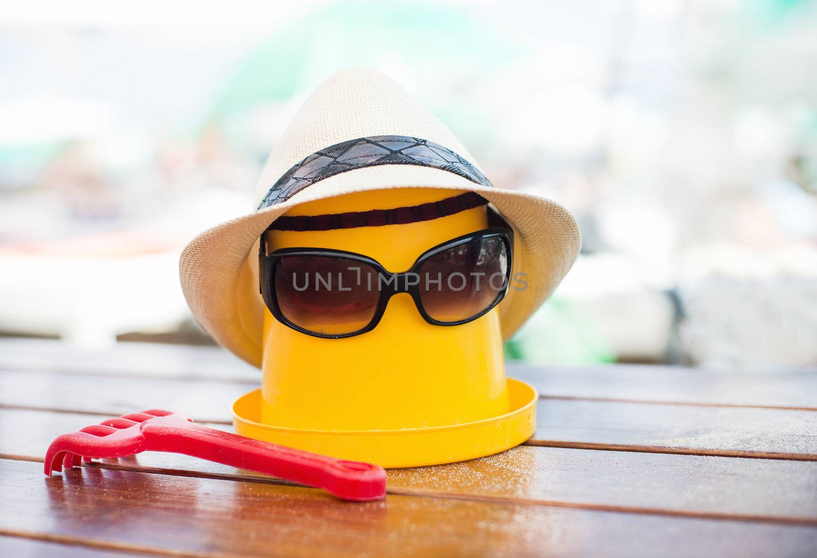 The Beach scene with bucket, hat and sunglasses