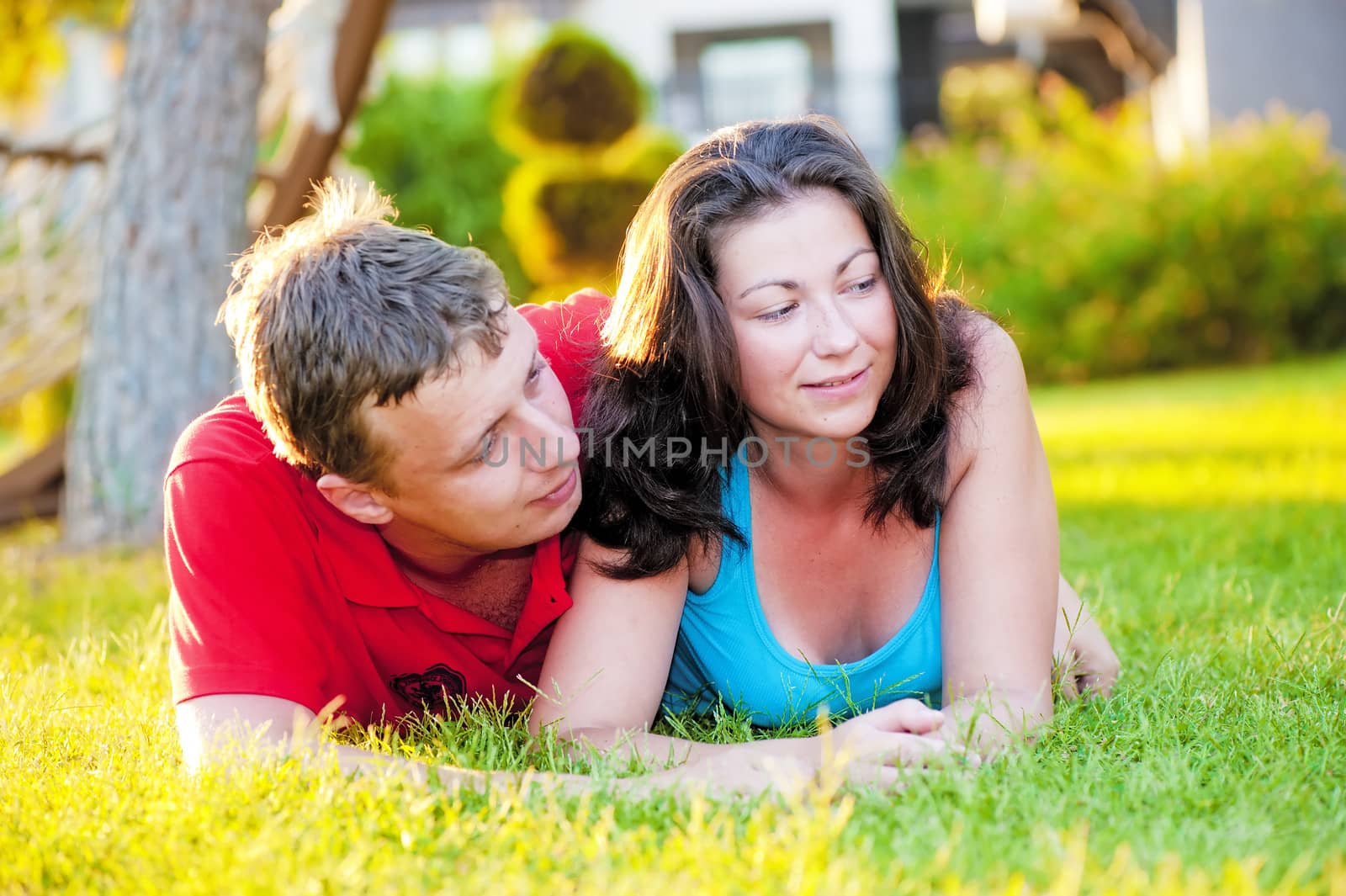 Young couple lying on the grass, and that it is considering