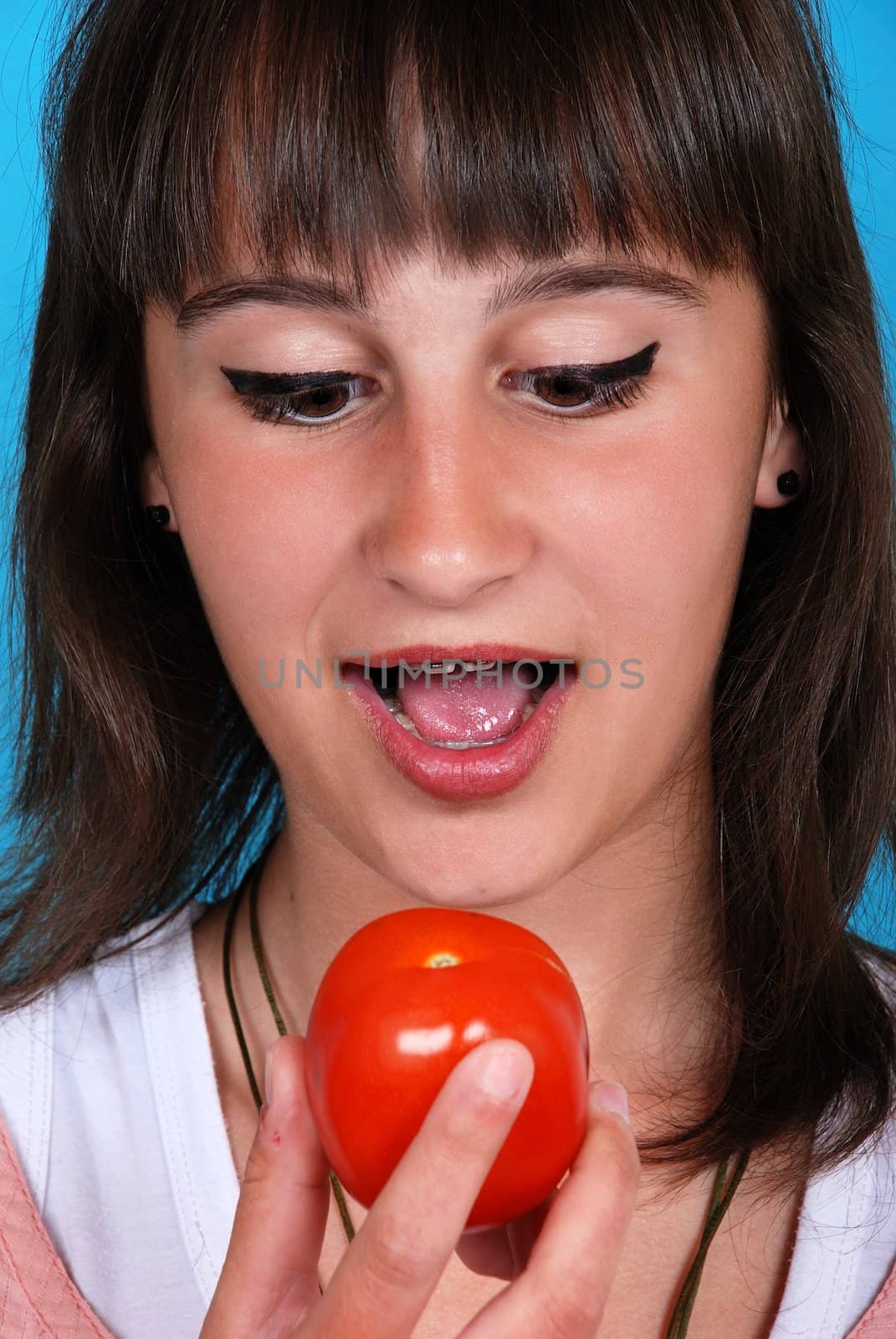 Girl eating a tomato
