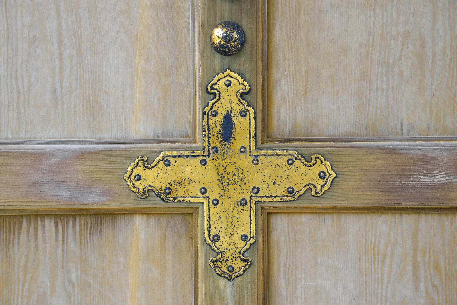 Golden cross on wooden wall by gjeerawut