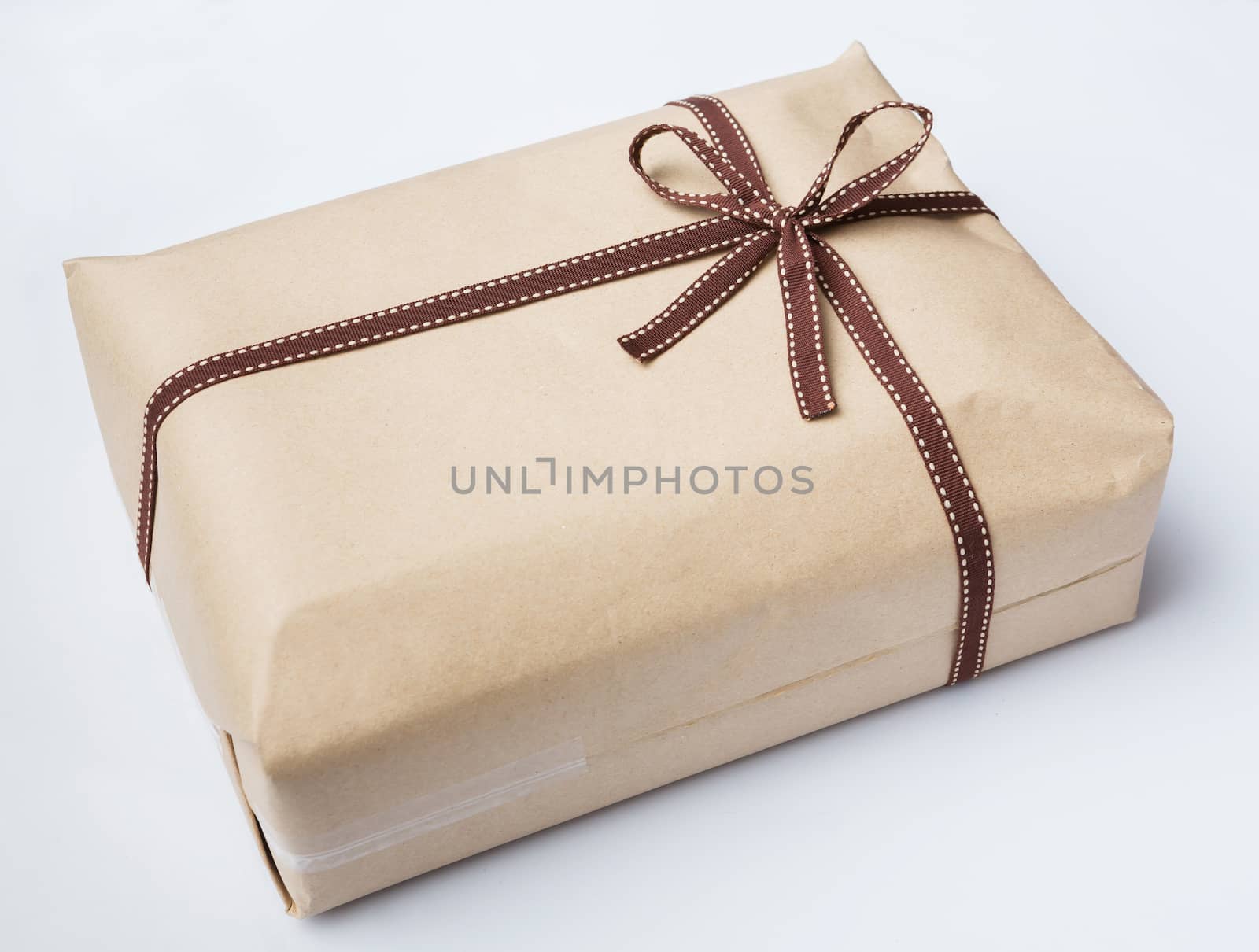 Wrapped gift box with brown paper and dark brown bow tie isolated on white