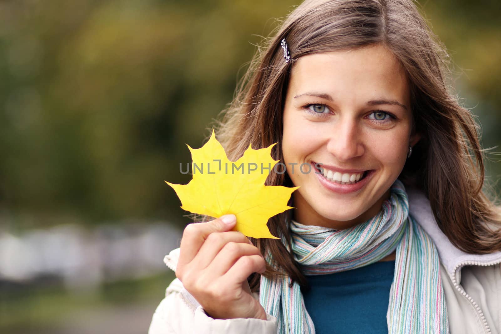 young beautiful woman with a bouquet of maple leaves