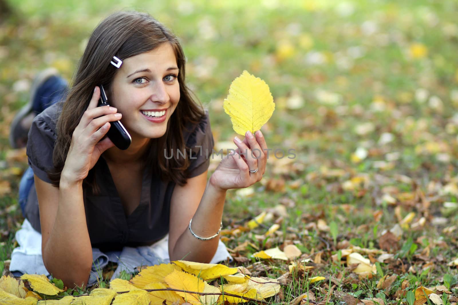 woman calling by phone in autumn park