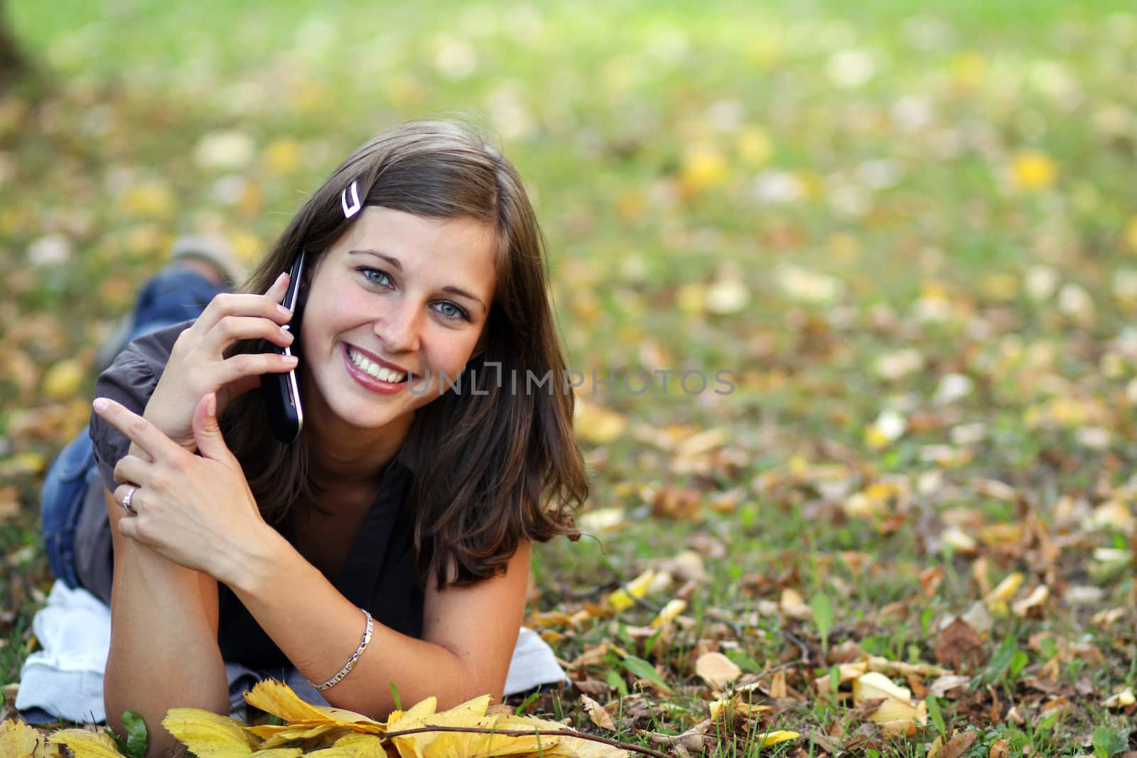 woman calling by phone in autumn park