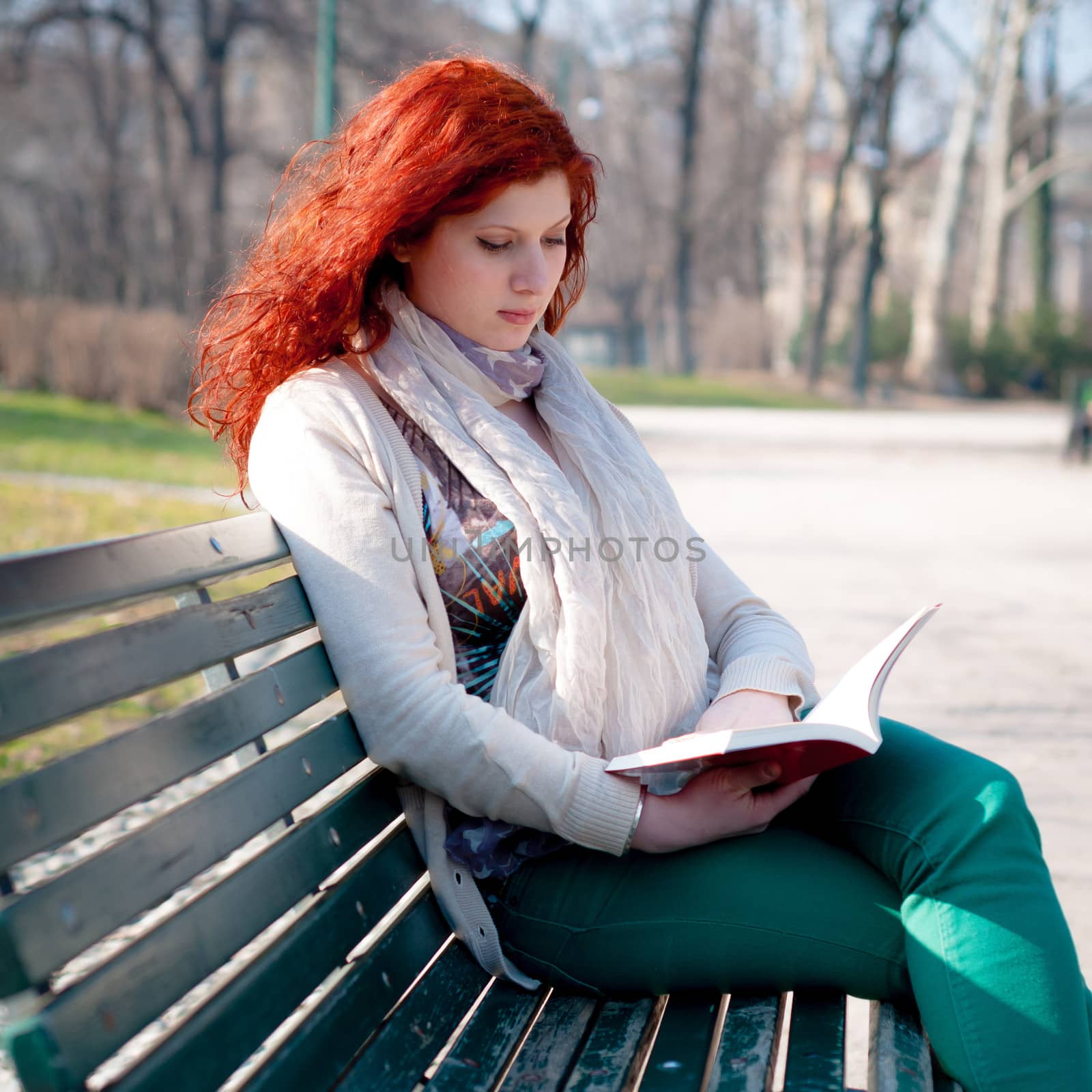 beautiful red head young woman reading book by peus