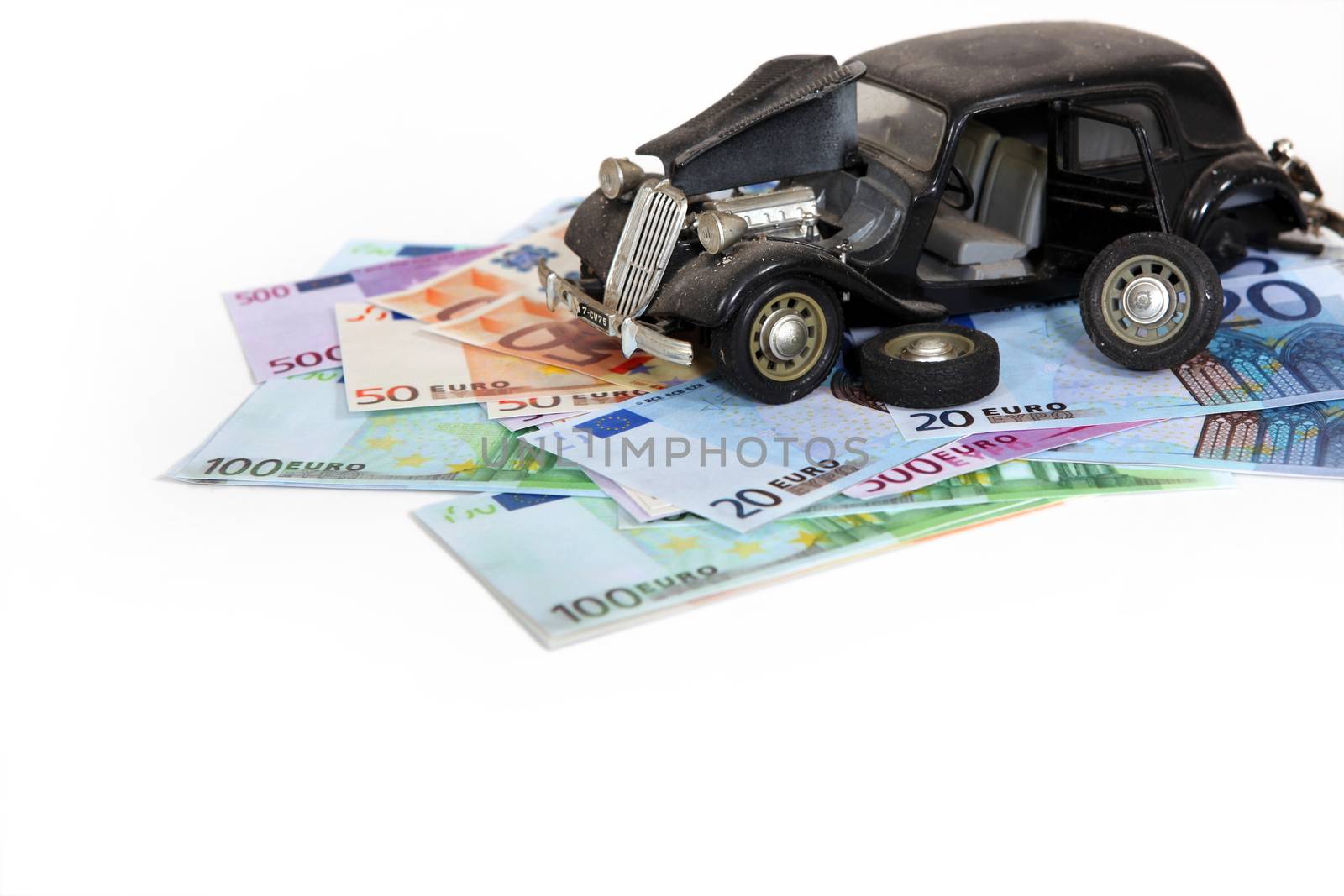 Symbolic broken car on top of cash