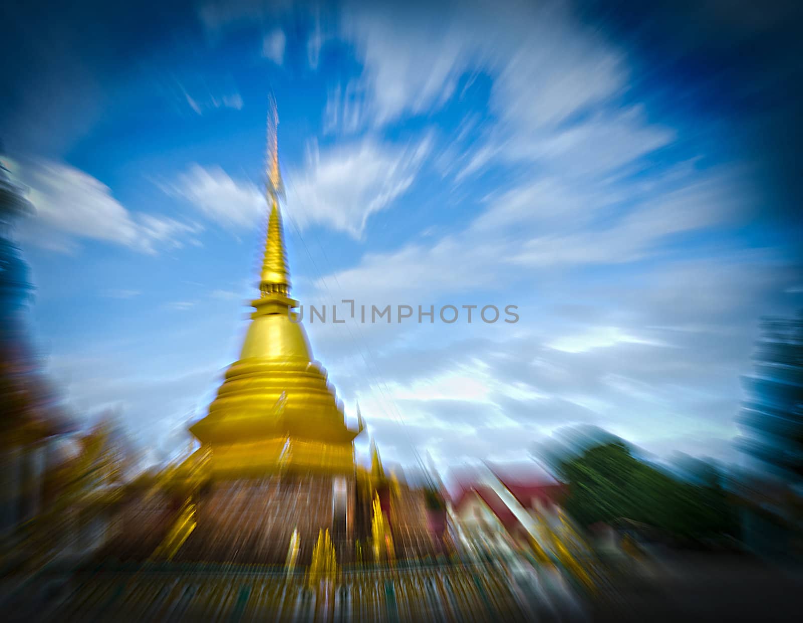 The Thai Golden Phra Tad or Pagoga with Blue Cloudy Sky and Zooming Technique.