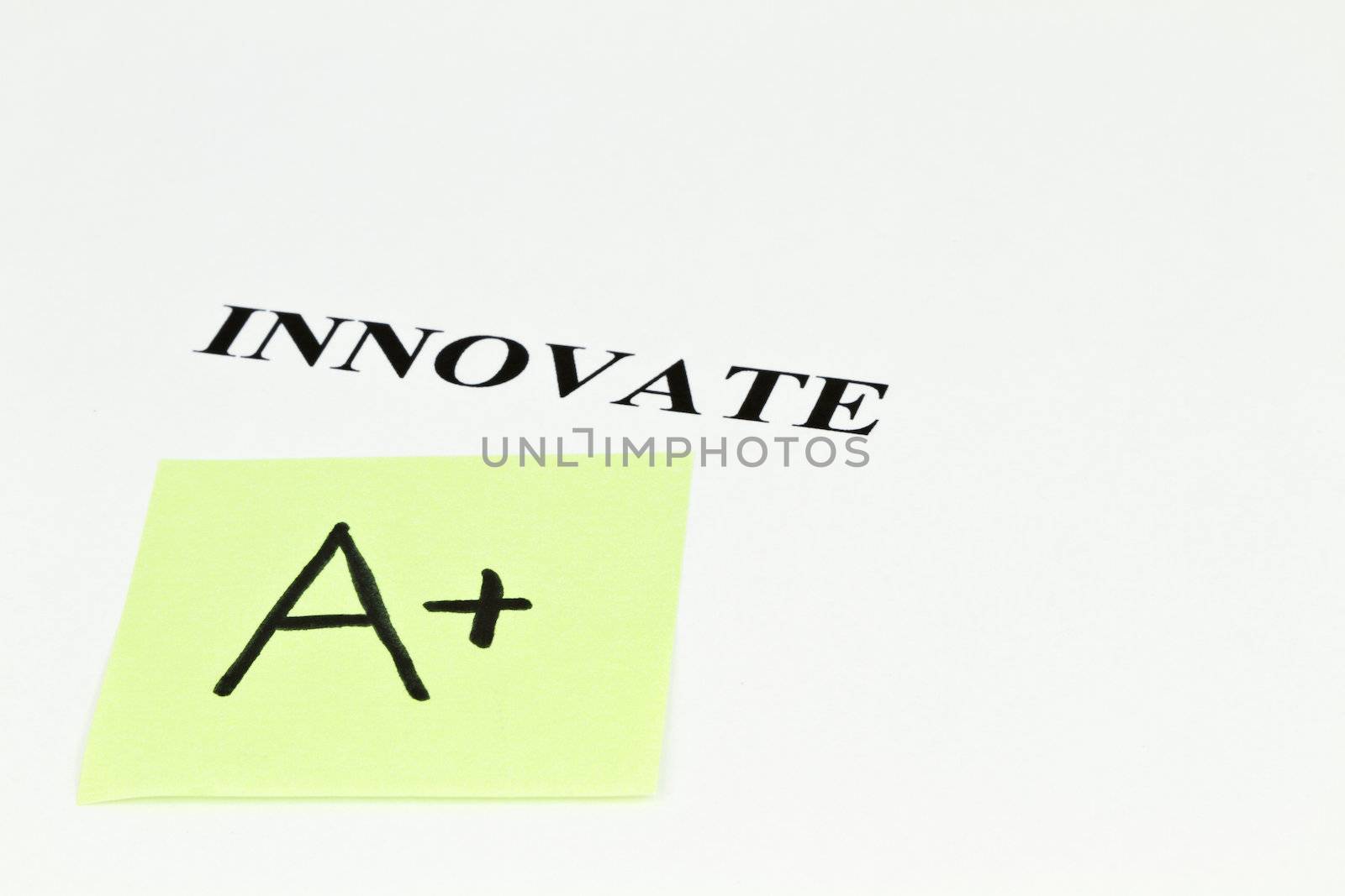 A+ grade note placed next to word, INNOVATE, on white background with copy space to right;
