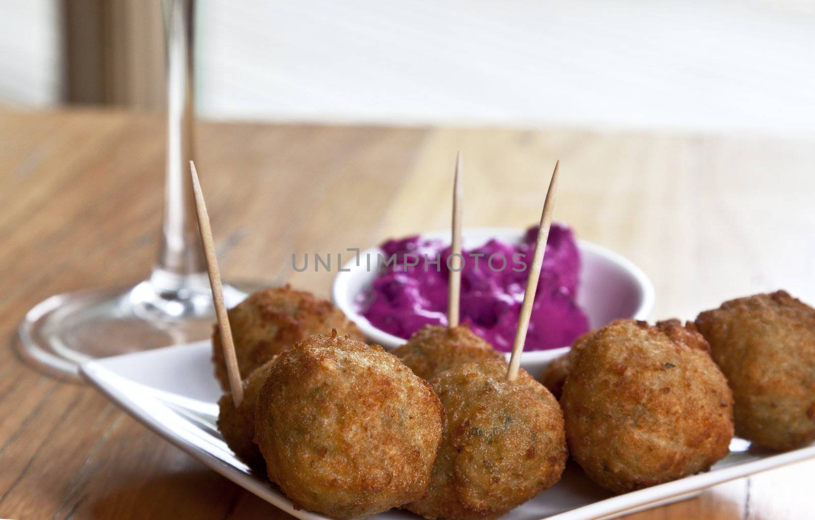 Fried hummus balls served as appetizers with beet root dip; location is on Mornington Peninsula, outside Melbourned, Victoria, in Australia. Hummus, with a Middle Eastern origin, is made from chickpeas