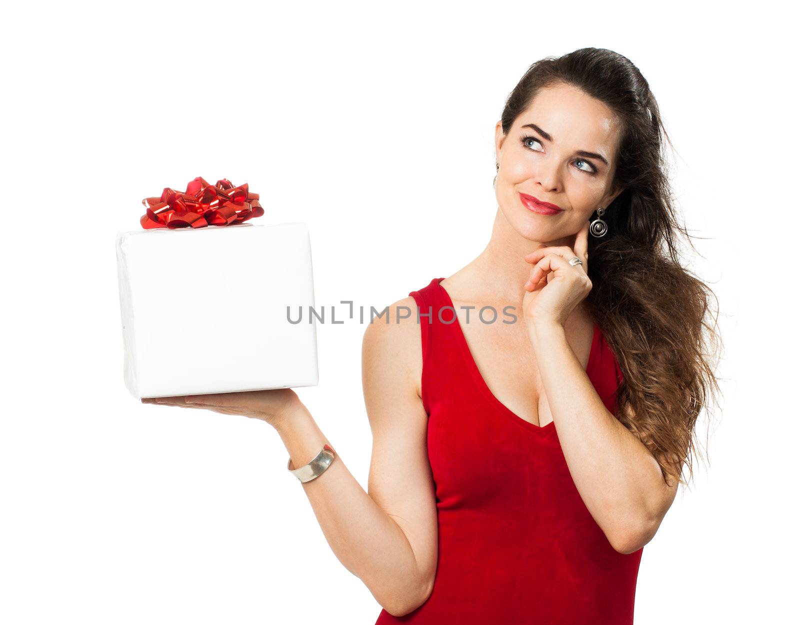 A beautiful woman holding up a beautiful gift and looks thoughtful. Isolated on white.