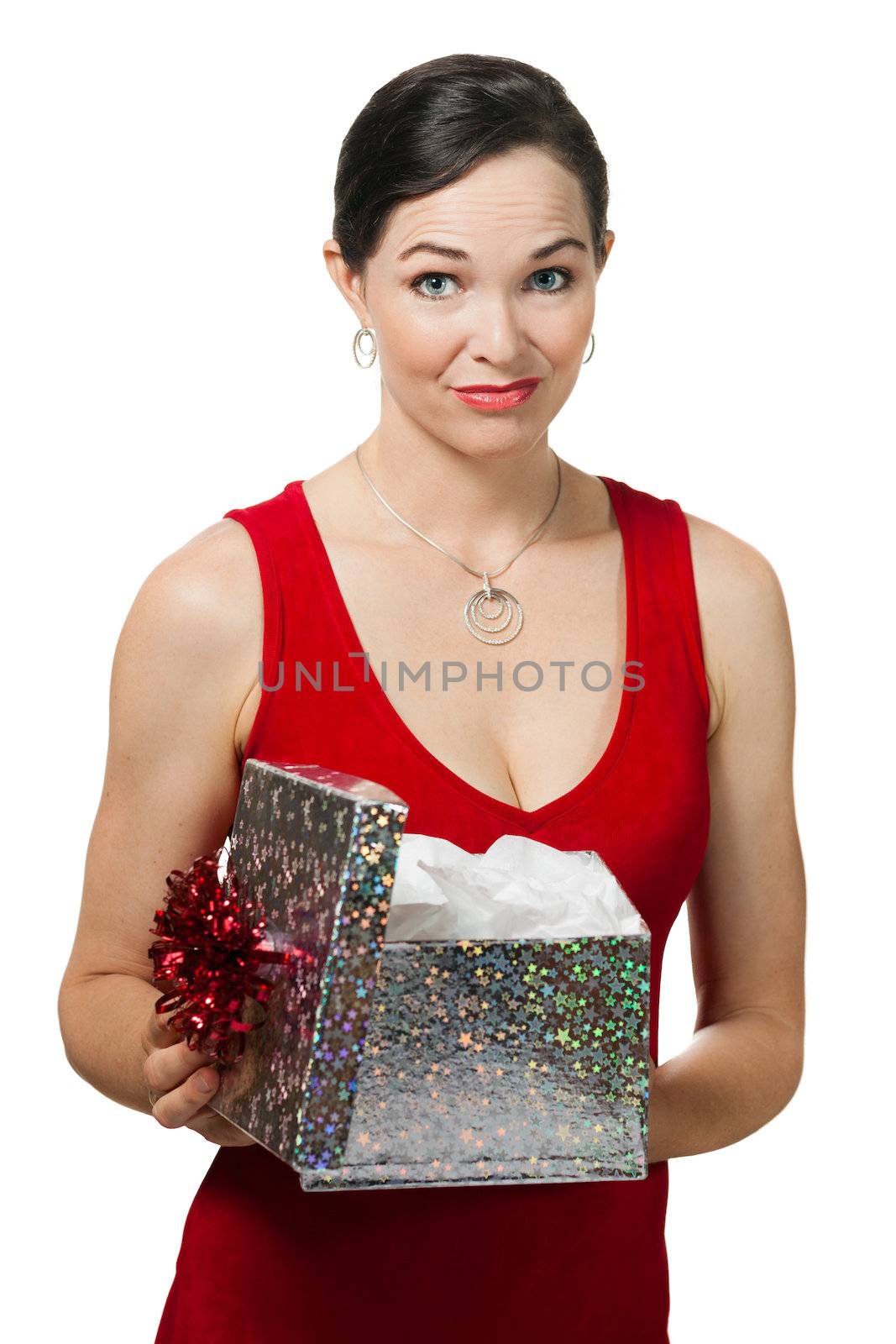 A woman disappointed woman holding a christmas gift she just opened. Isolated on white.