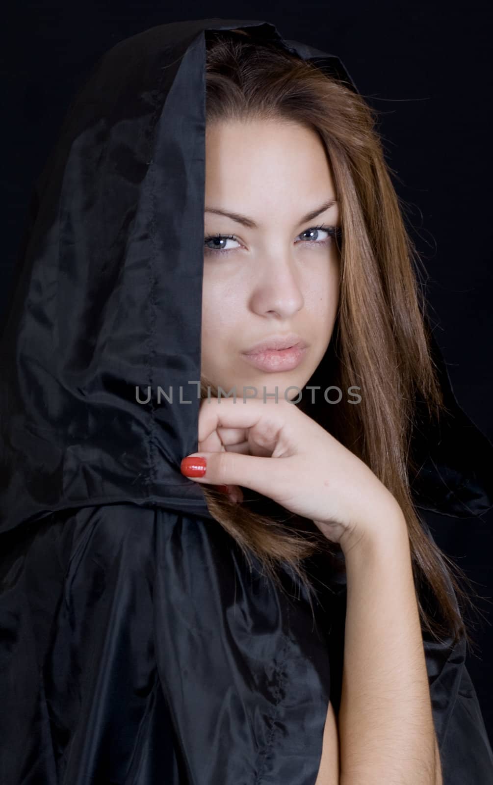 Dramatic portrait of a young lady in a black cape, may-be a young witch