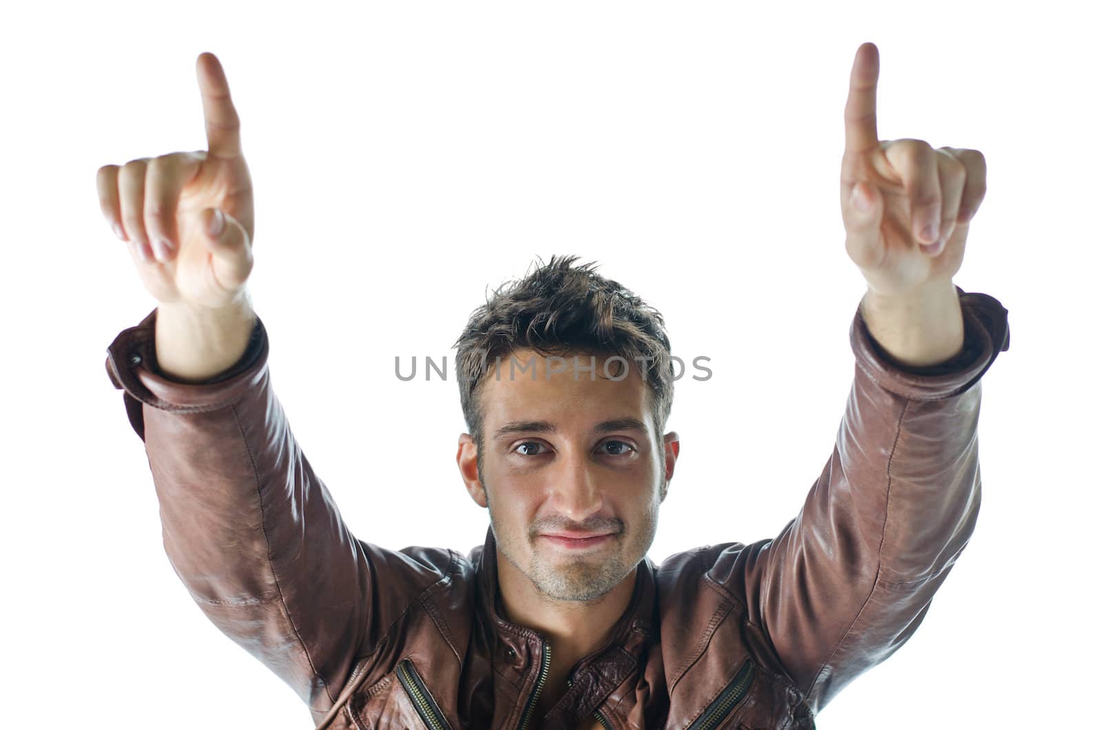 Smiling and confident young man pointing fingers up and looking in camera, isolated on white