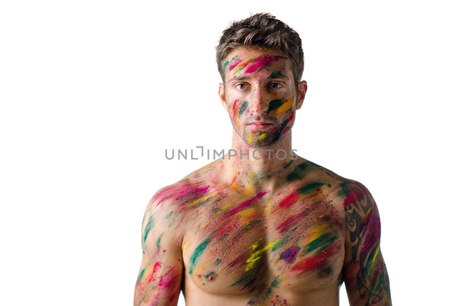 Attractive and athletic shirtless young man, skin painted all over with Holi colors, isolated on white