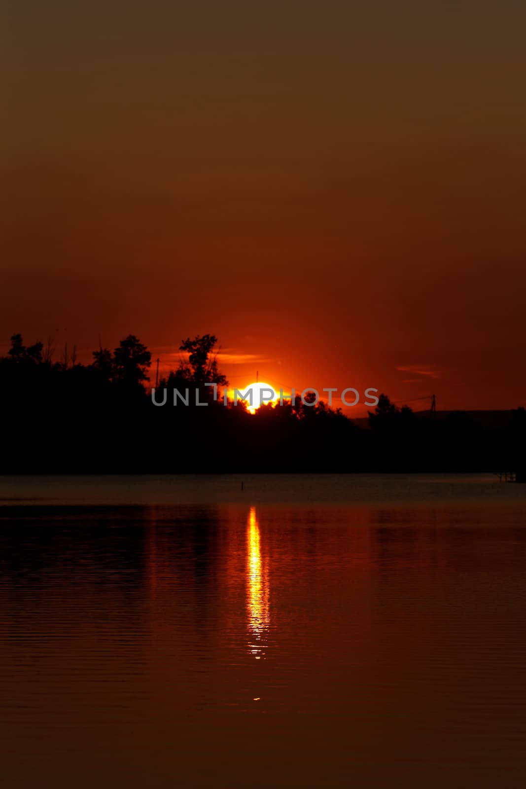 Colorful sunset over tranquil water surface.