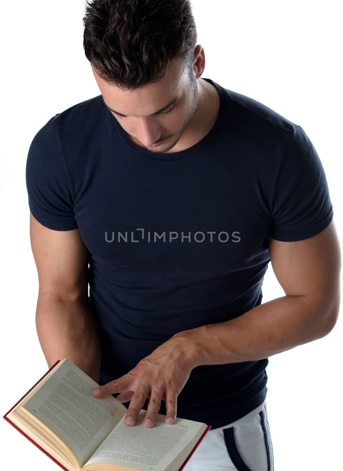 Attractive and athletic young man standing and reading book, isolated on white