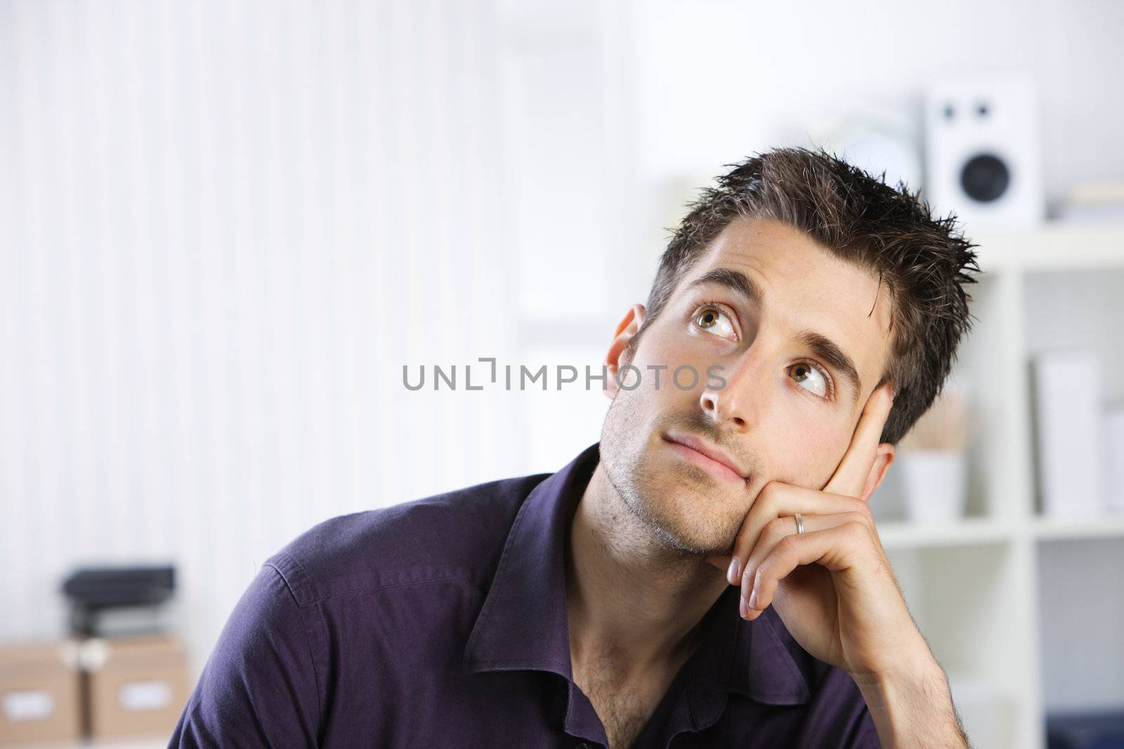 Portrait of a casual young man looking up, copy space