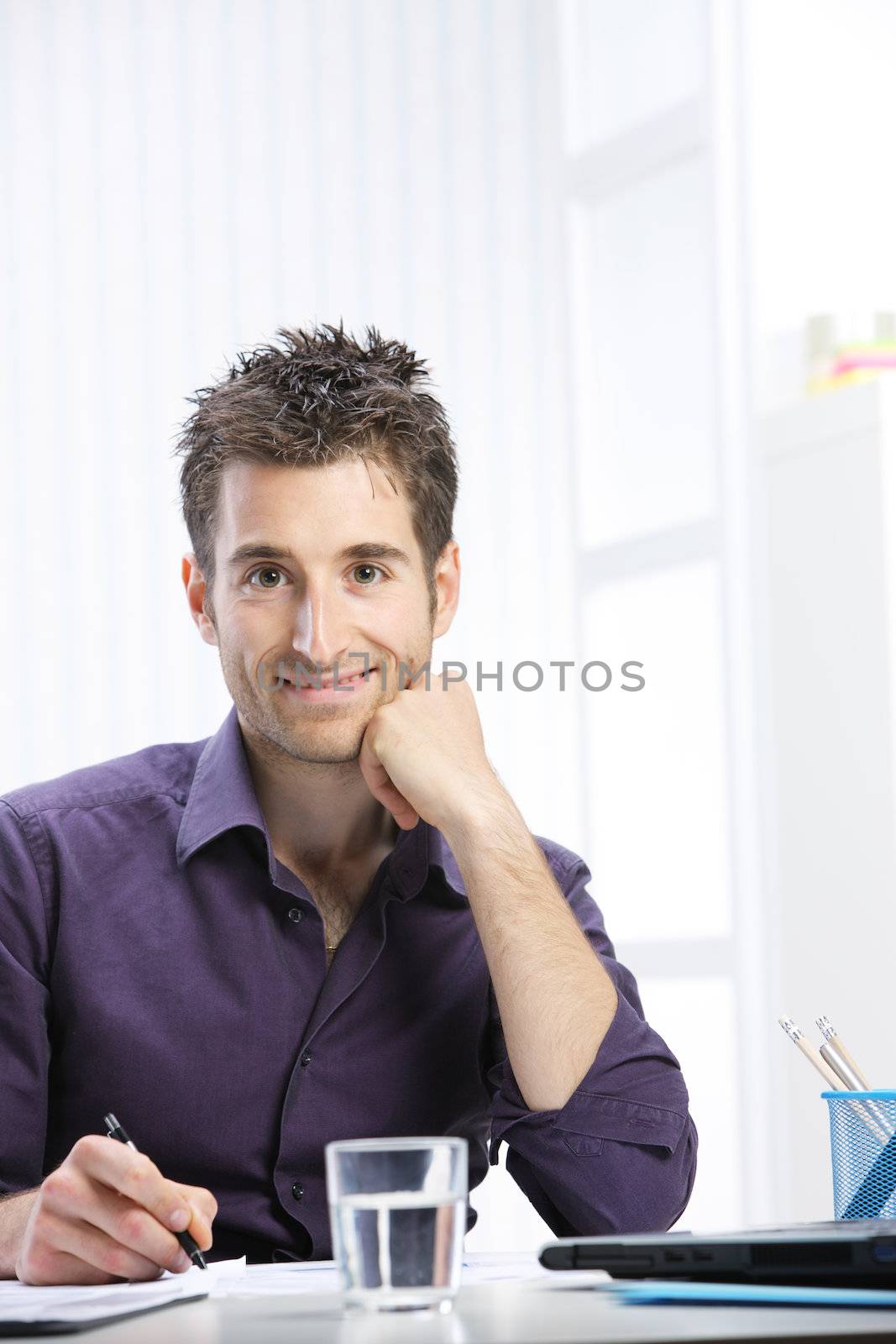 Portrait of a young man working at desk