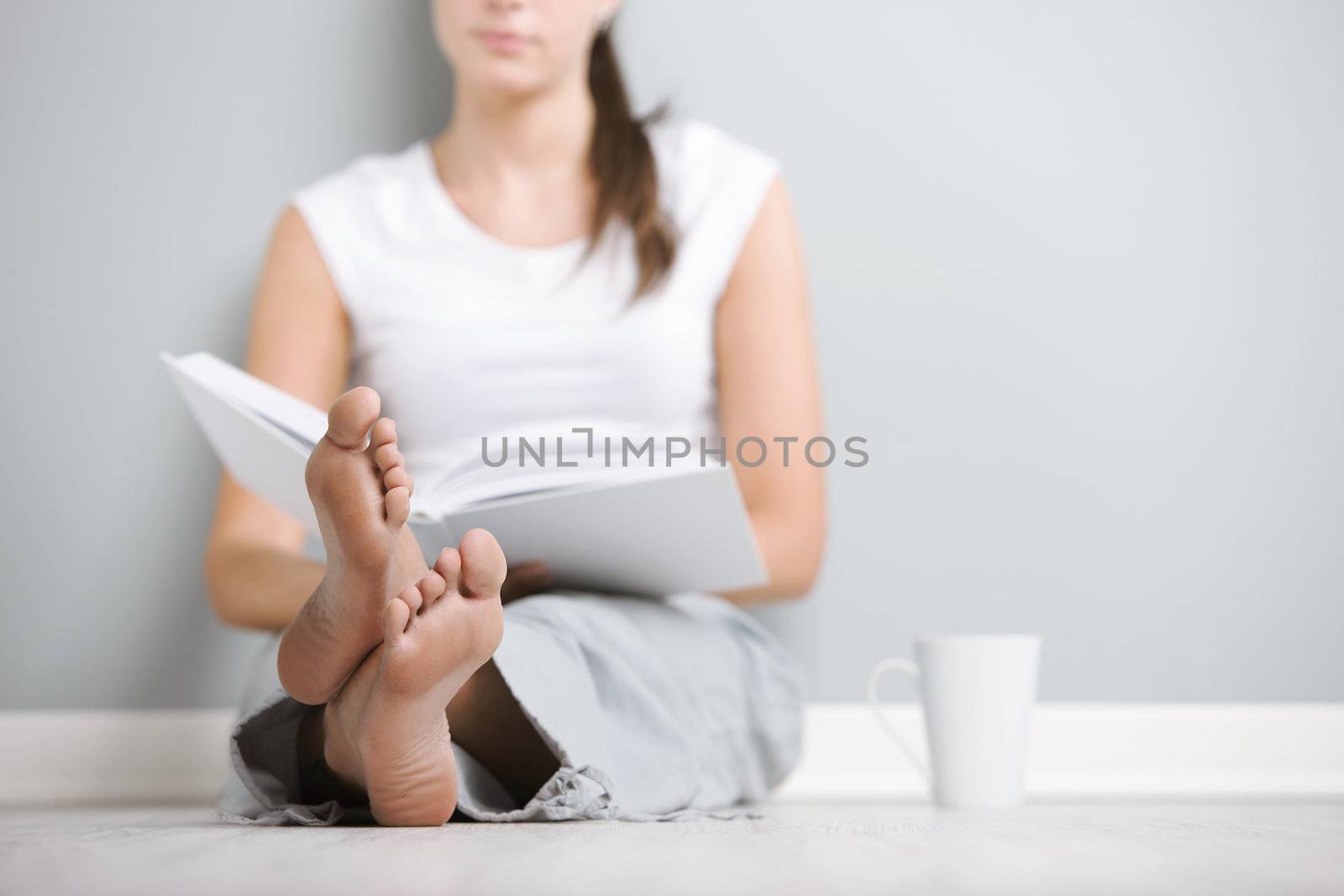 Young woman relaxing at home reading a book