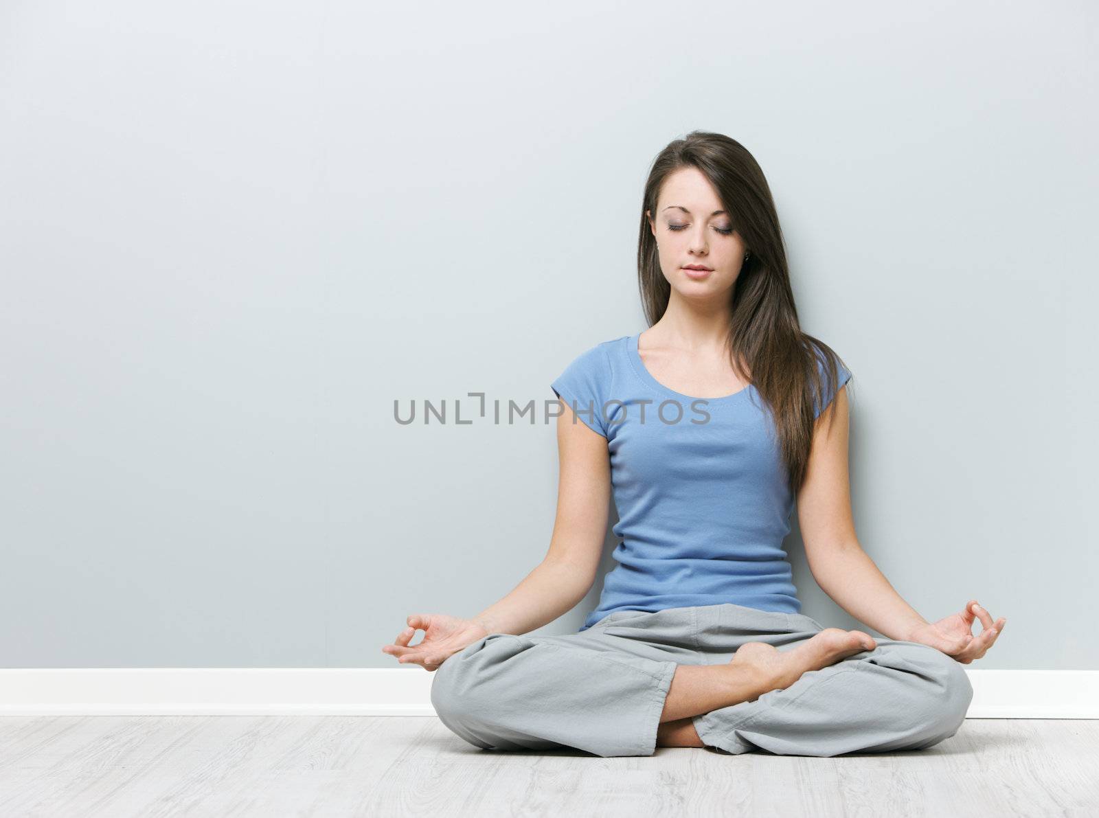 Young woman in the lotus position while meditating 