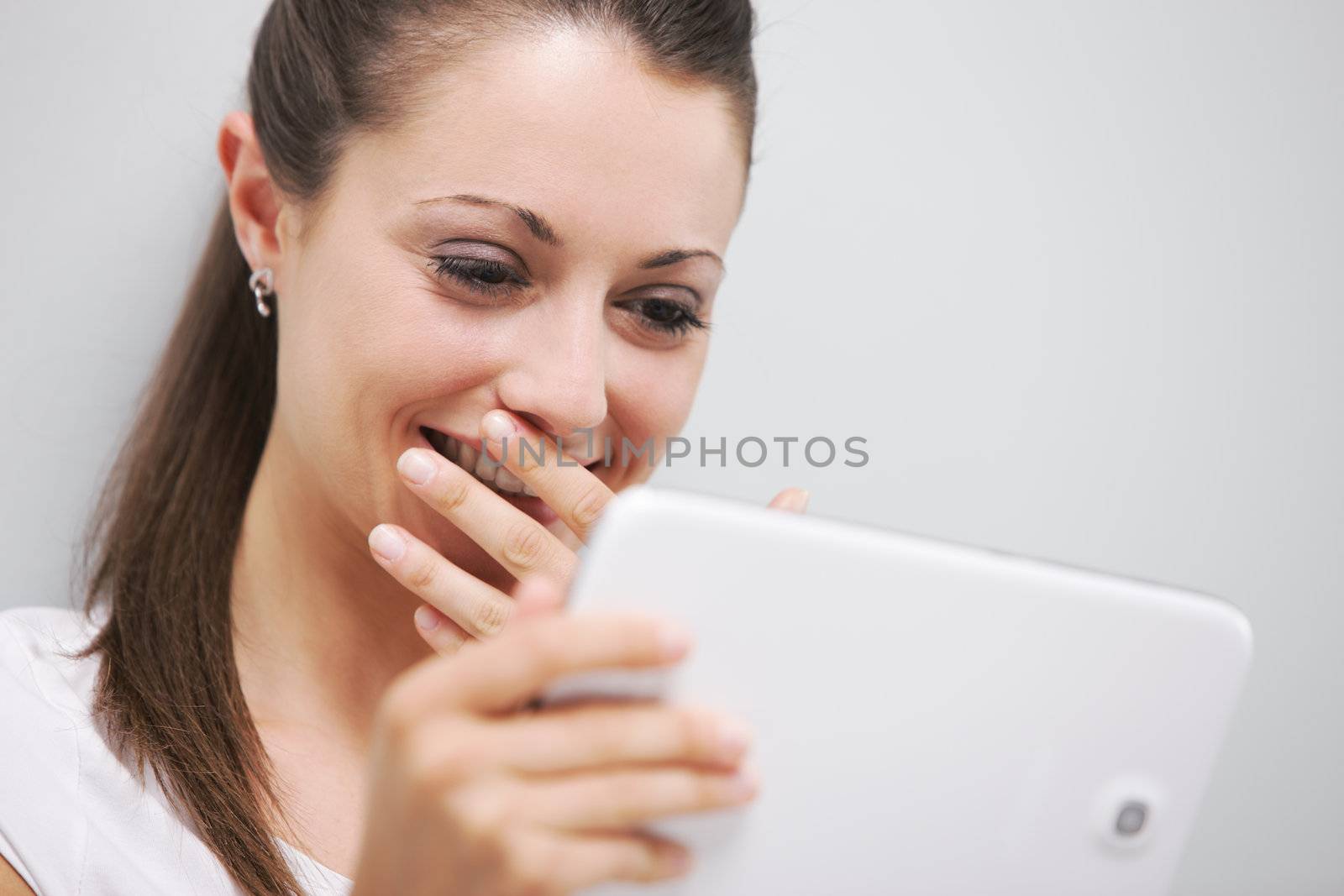Cheerful woman watching a funny movie on her digital tablet