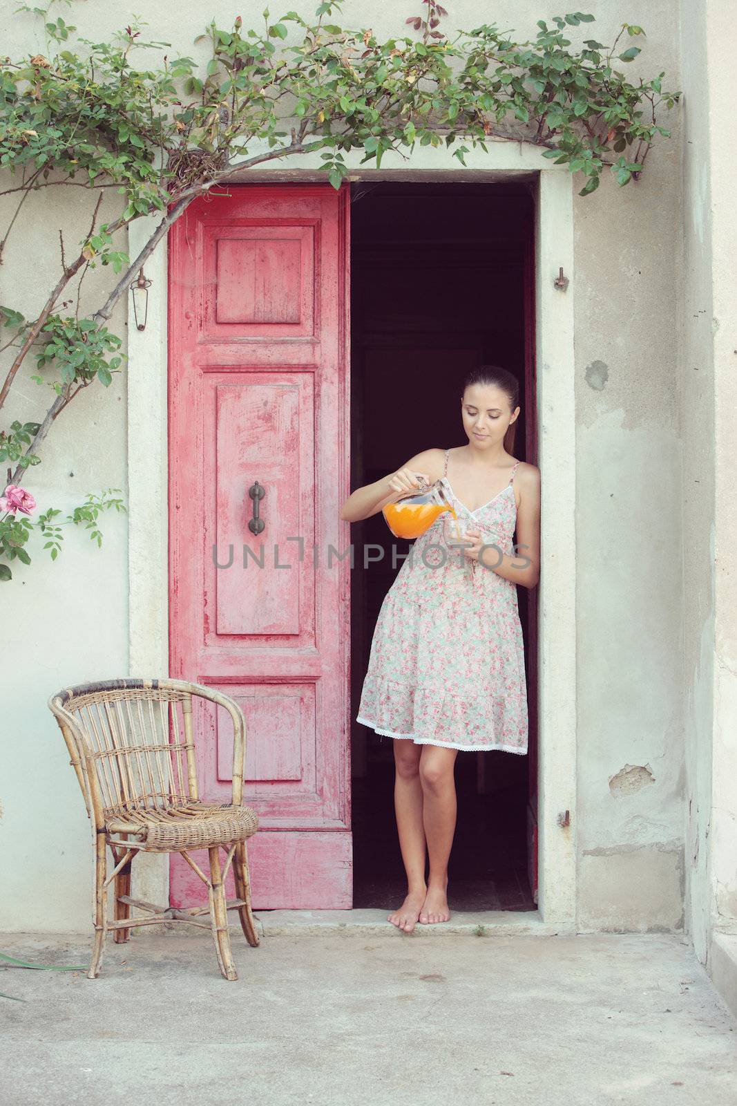 Young woman pouring orange juice in a glass