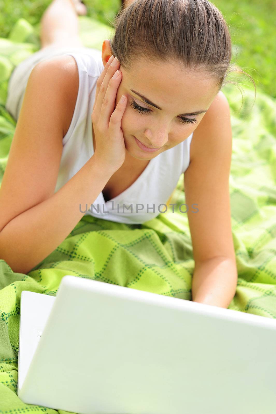 Cheerful girl working in laptop outdoors in a sunny day