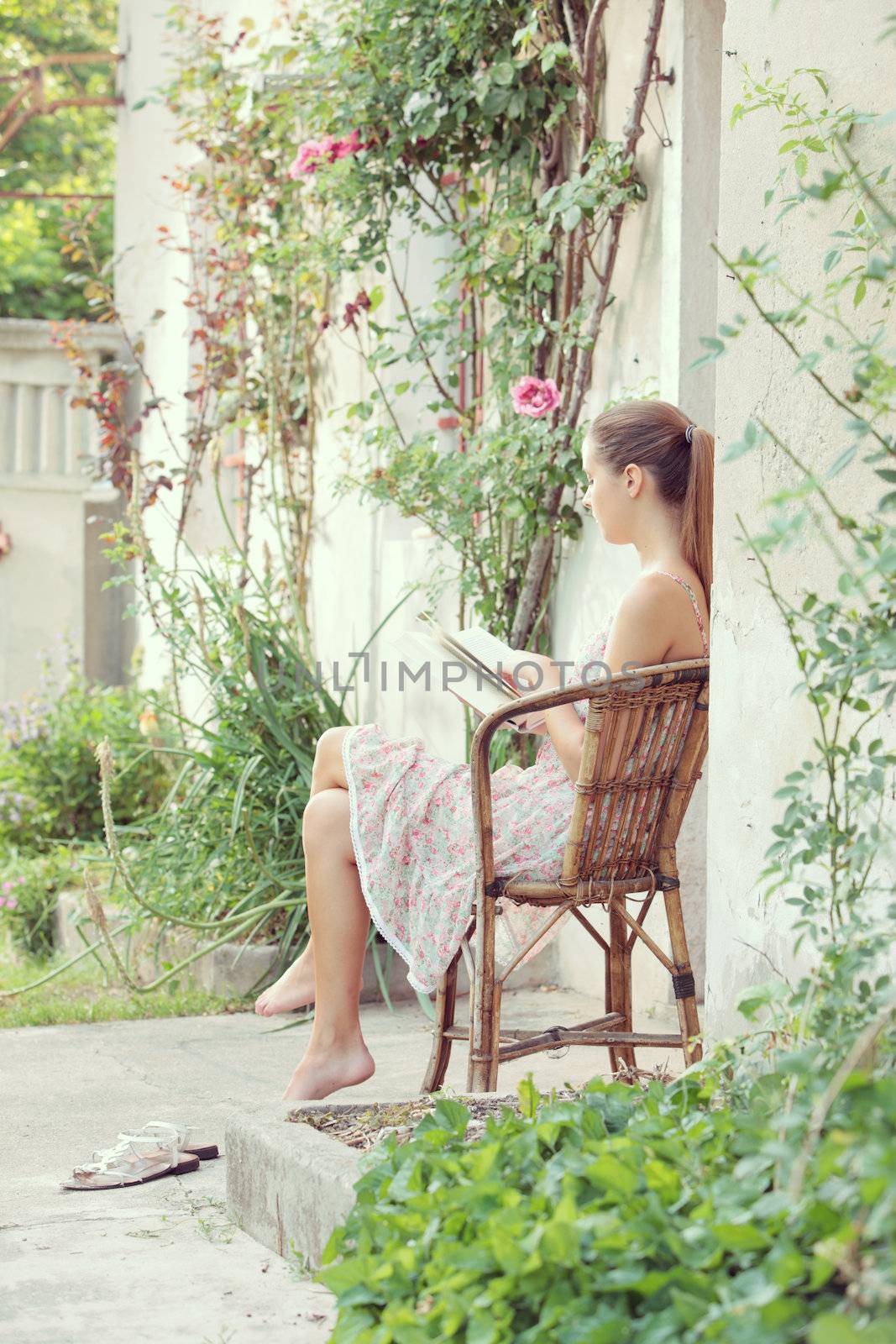 Beautiful girl reading a book outdoors enjoying a summer day