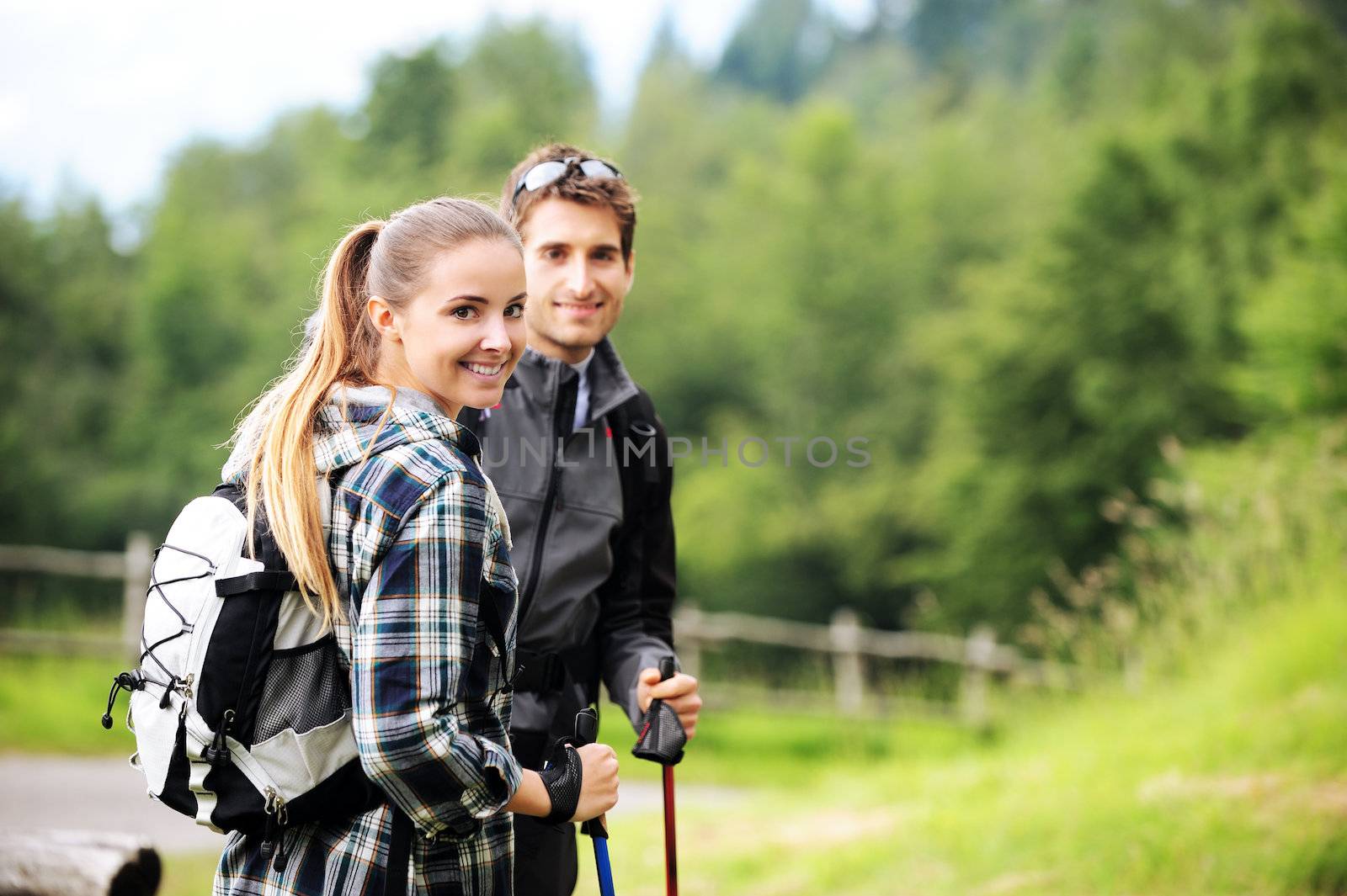 Young cheerful couple enjoying a nordic walk 