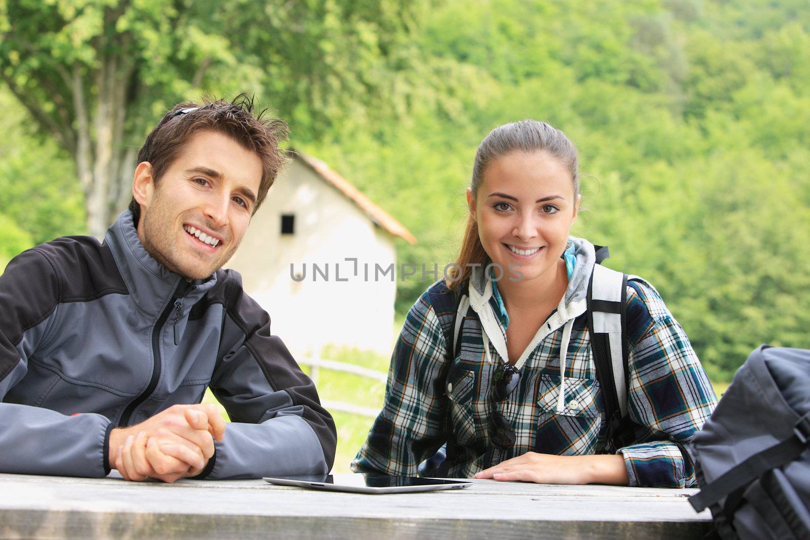 Portrait of happy hikers couple resting outdoors