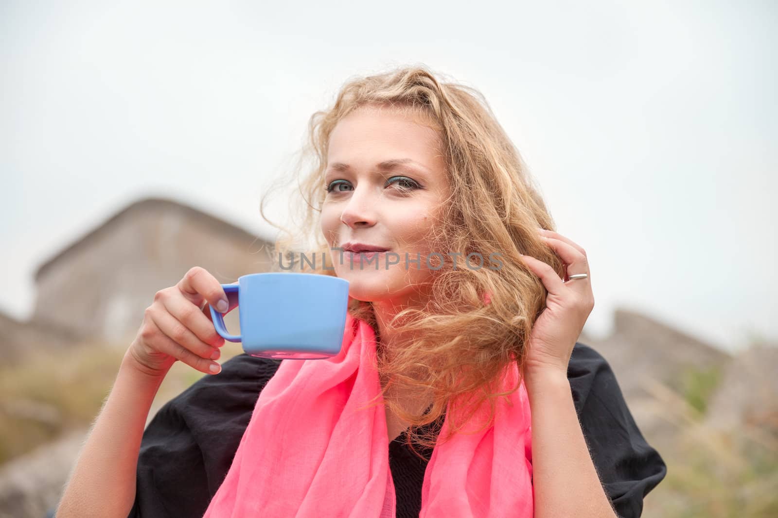 Young happy smiling woman drinking coffee outdoors.