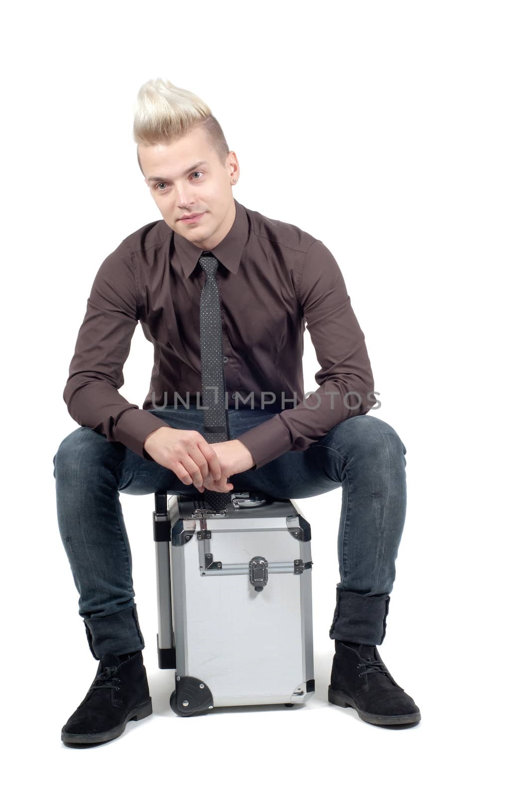 Handsome man sitting on the suitcase by anytka