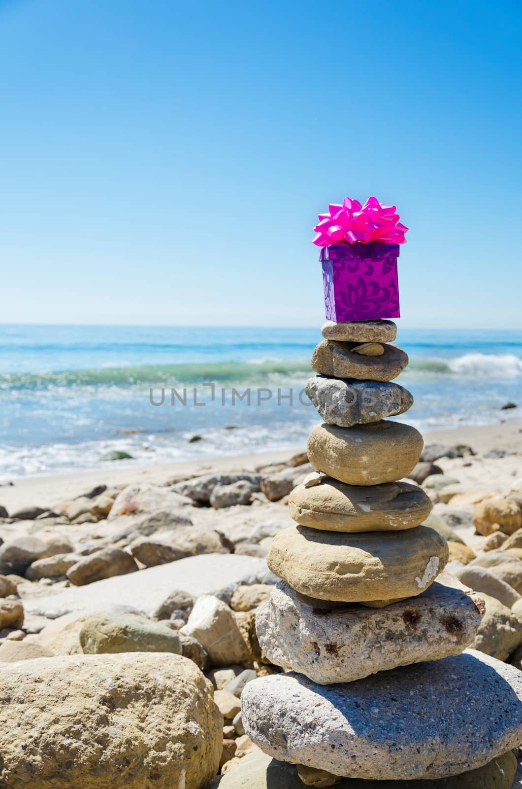 Gift box on the top of sea rocks balancing by Pacific ocean