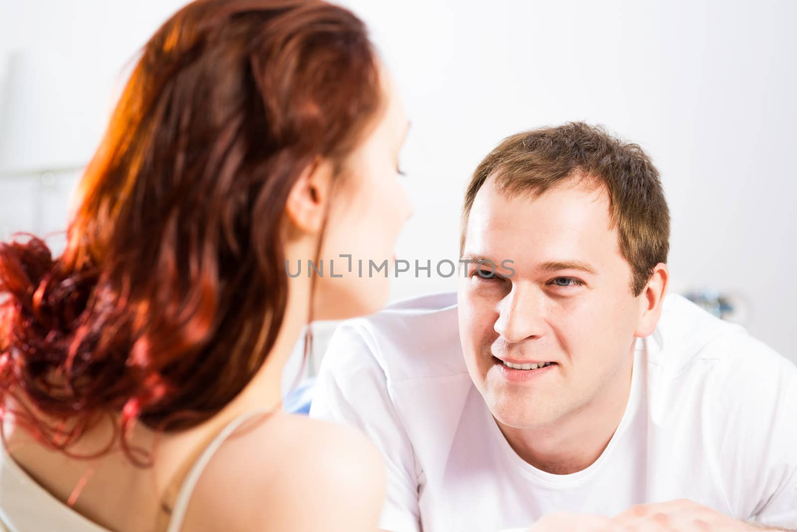 young man lying in bed with his girlfriend, spend time together at home