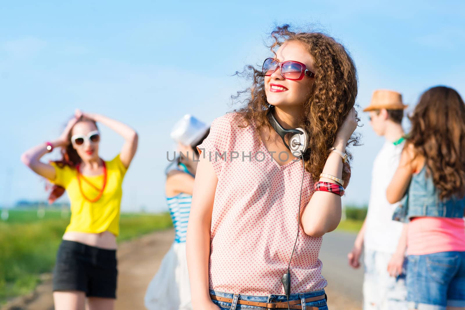 young woman with headphones on a background of blue sky and funny friends