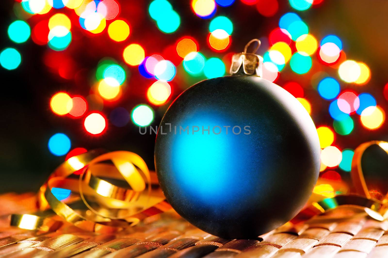 Blue Christmas ball on the background of blurred lights garlands.