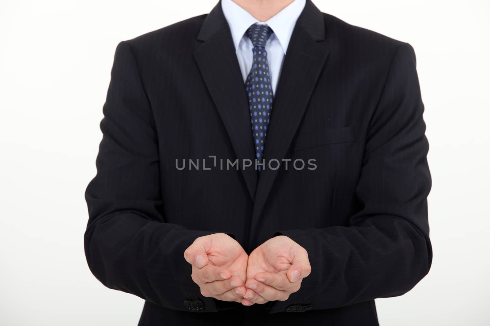Businessman holding hands out by phovoir
