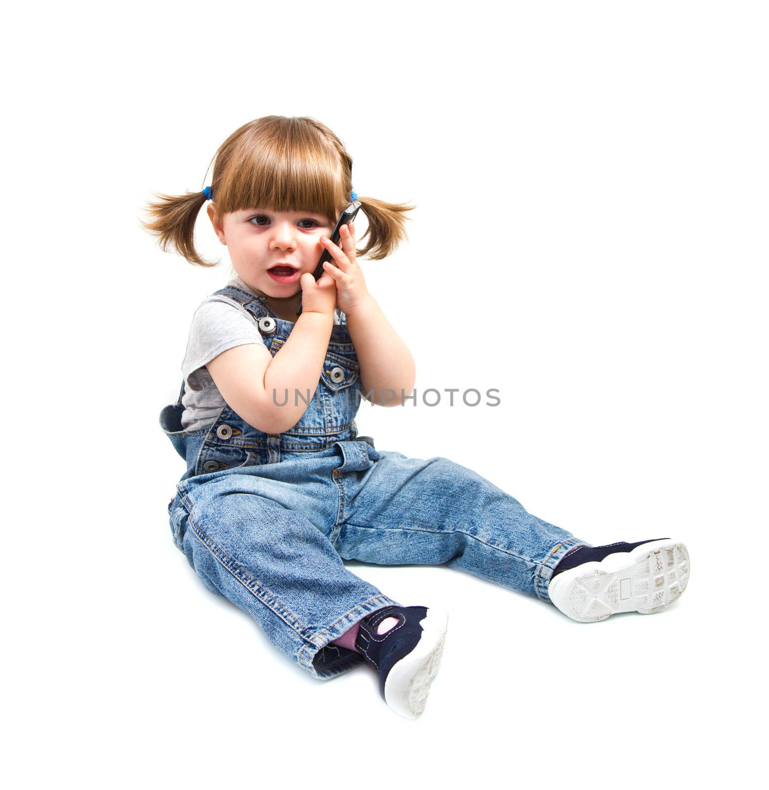 Cute little baby is talking on cell phone, isolated over white 