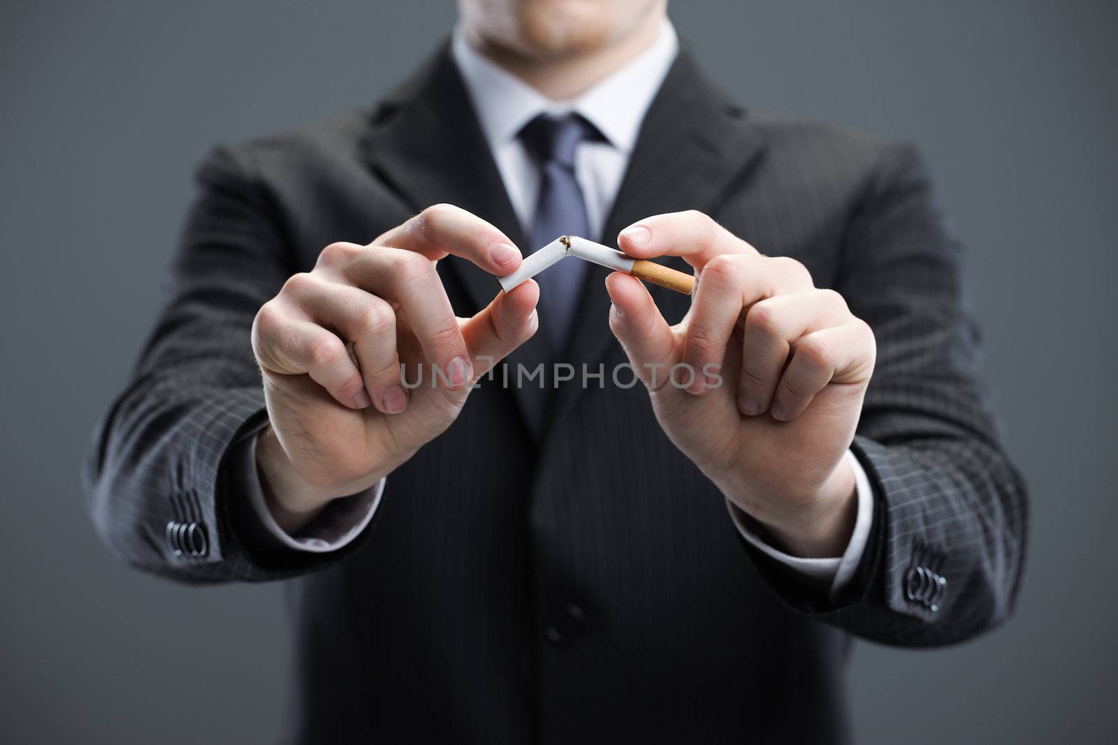 Human hands breaking cigarette 