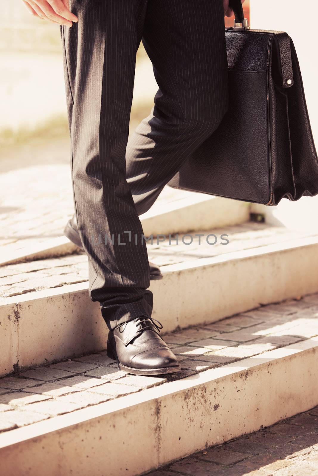 Businessman walks with his briefcase down a staircase