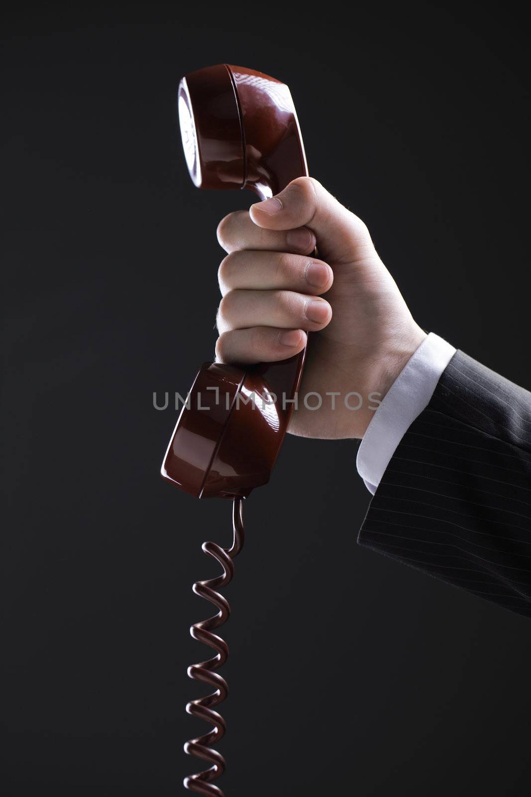 Businessman holding out a red phone, hand close up