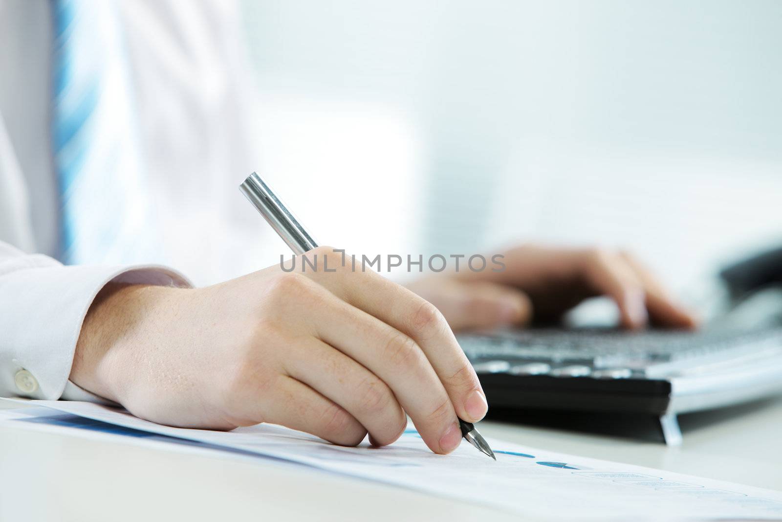 Close up image of businessman writing at workplace