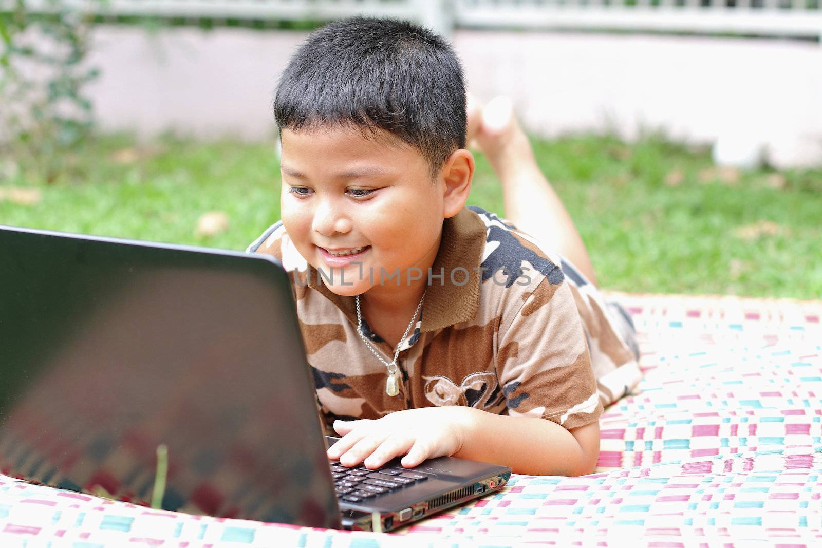 Boy playing laptop. Happily.