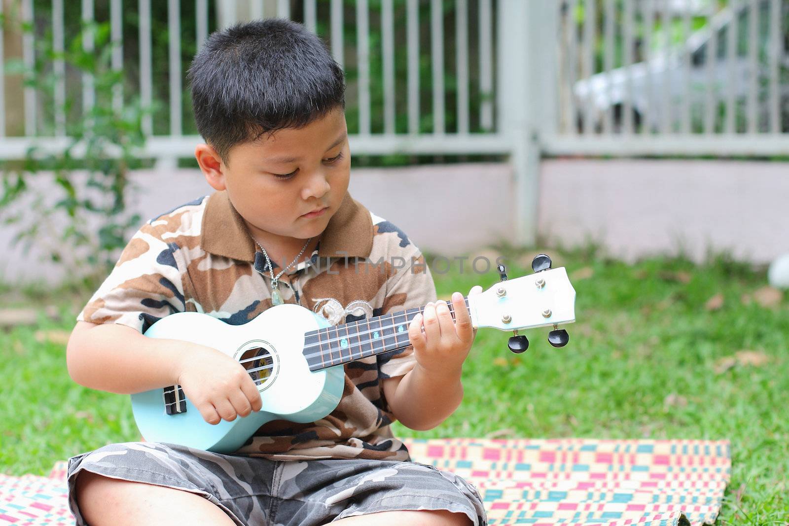 Boy playing the ukulele fun.