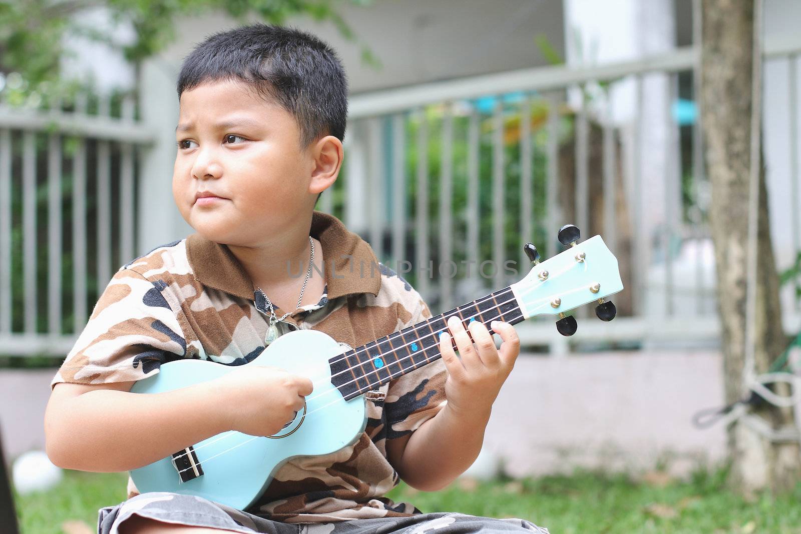 Boy playing the ukulele fun.