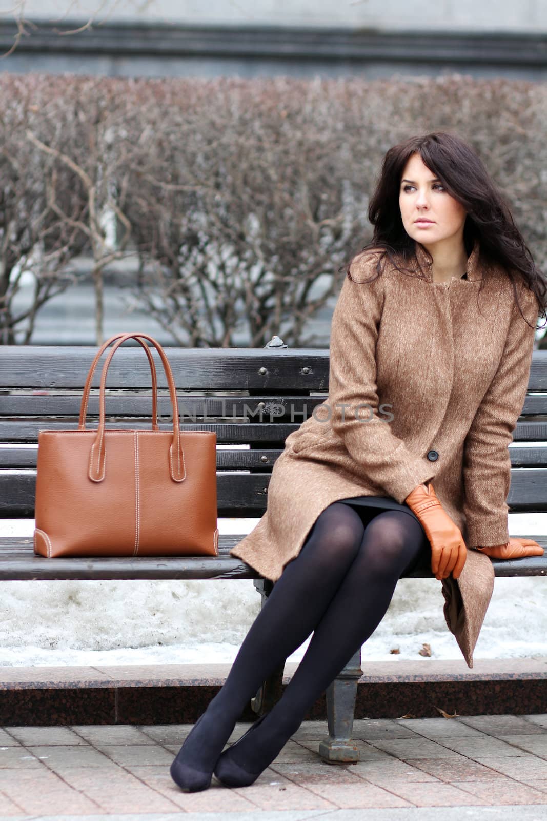 beautiful young city woman sits on a bench by andersonrise