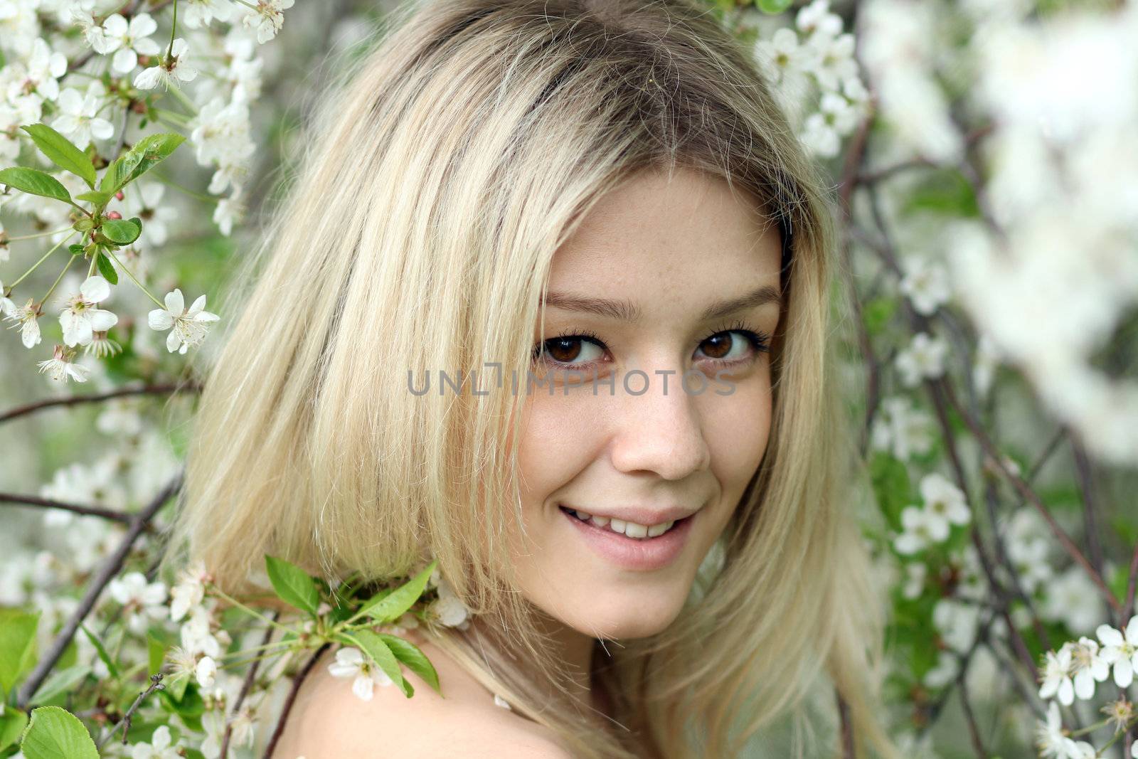 Portrait of beautiful blond in spring blossom