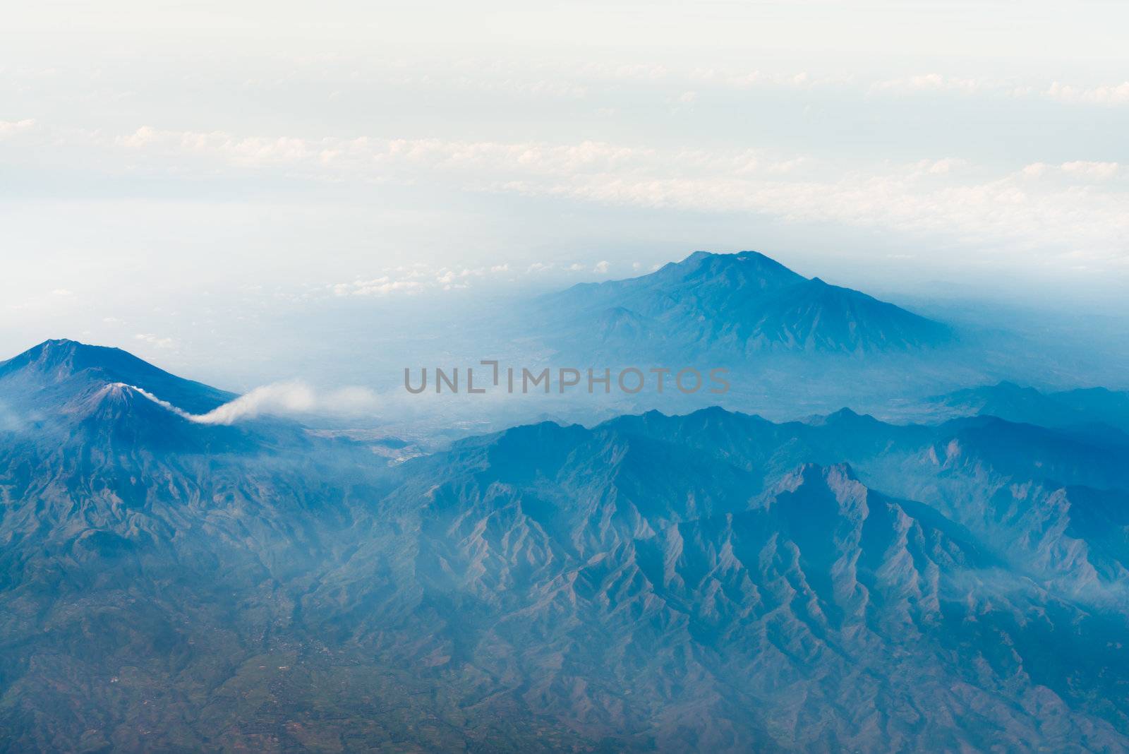 Volcano tops with smoke under sky, bird's eye view. Java island, Indonesia